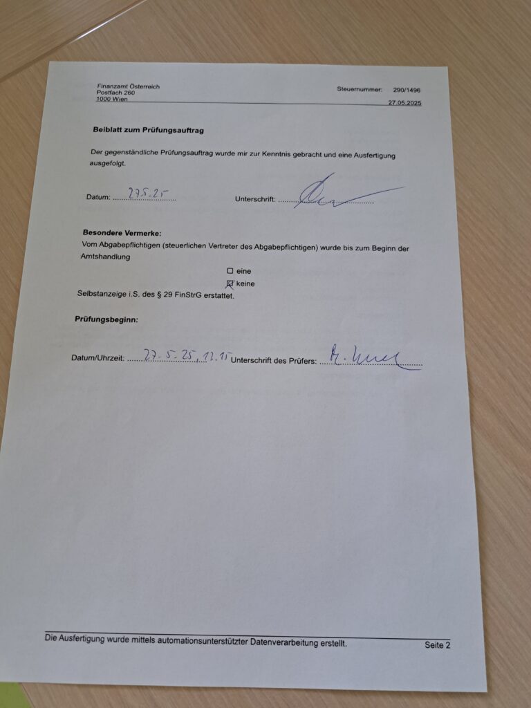 Ein Prüfungsauftrag Dokument mit Datum und Unterschrift auf einem Tisch.
